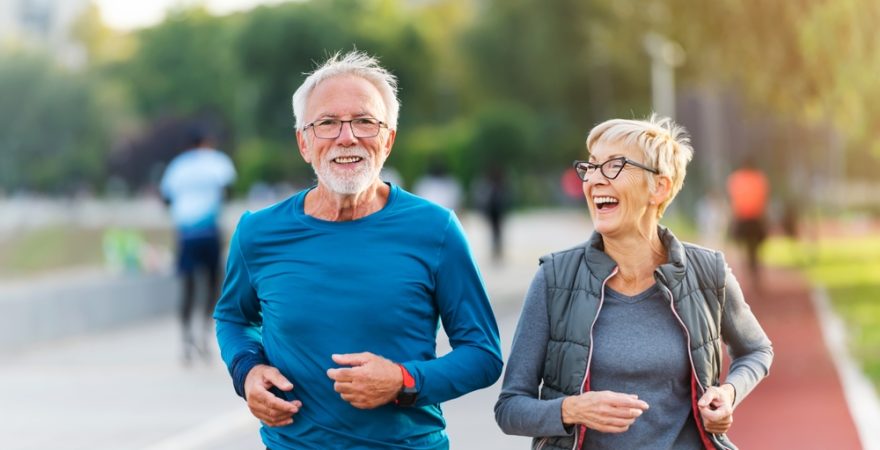 Cheerful,Active,Senior,Couple,Jogging,Together,Outdoors,Along,The,River.
